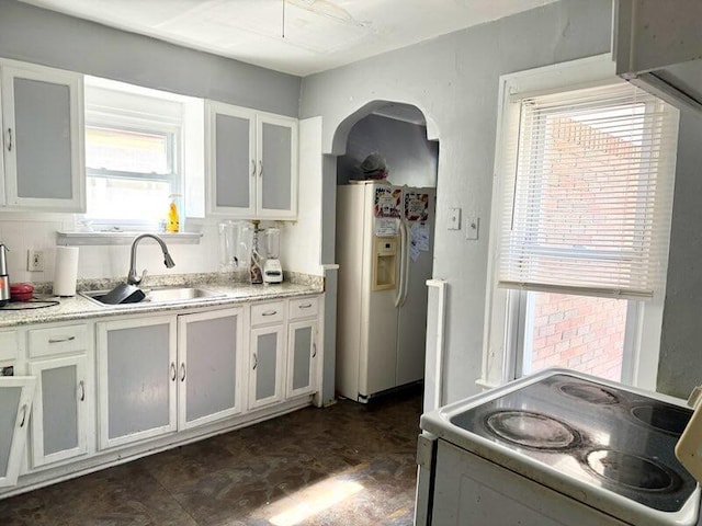 5793 Yorkshire Rd, Detroit, MI 48224 - kitchen featuring arched walkways, a sink, white appliances, and white cabinets