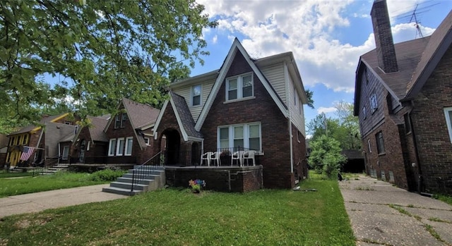 5793 Yorkshire Rd, Detroit, MI 48224 - tudor-style house featuring a front yard and brick siding