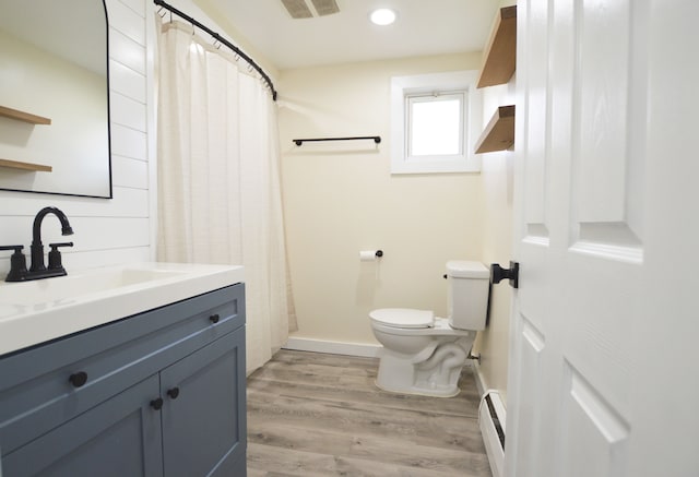 11391 Wing Dr, Clio, MI 48420 - bathroom with baseboards, toilet, a baseboard radiator, vanity, and wood finished floors