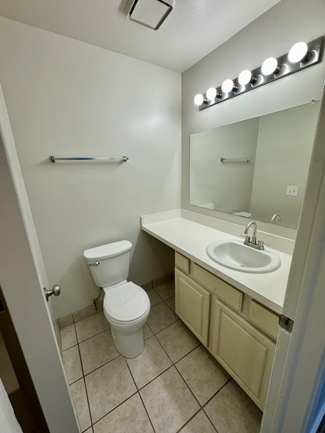 half bath with toilet, tile patterned flooring, baseboards, and vanity