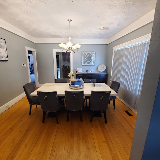 11060 Wilshire Dr, Detroit, MI 48213 - dining room with light wood-style flooring, baseboards, a notable chandelier, and visible vents