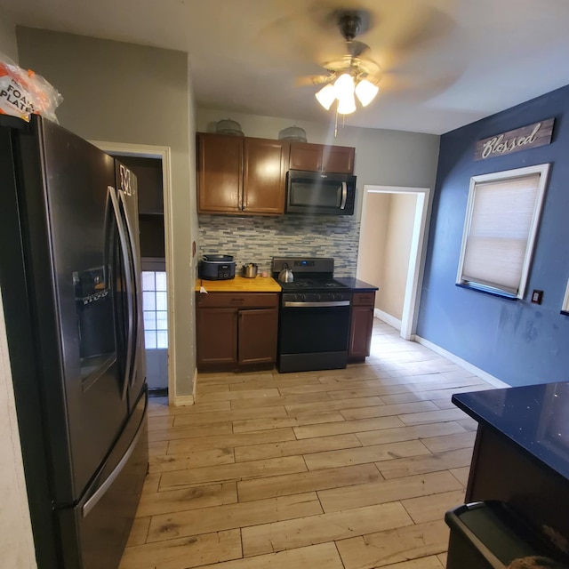 11060 Wilshire Dr, Detroit, MI 48213 - kitchen featuring baseboards, a ceiling fan, light wood finished floors, black appliances, and decorative backsplash