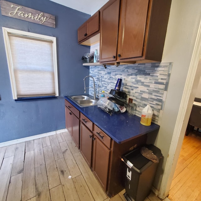 11060 Wilshire Dr, Detroit, MI 48213 - kitchen with a sink, backsplash, dark countertops, and light wood-style floors