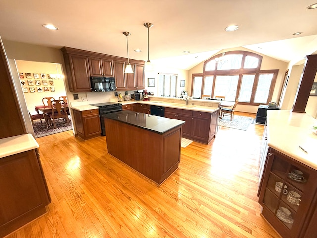 5280 Inverrary Ln, Commerce Twp, MI 48382 - kitchen featuring black appliances, a peninsula, light wood-style flooring, vaulted ceiling, and a kitchen island