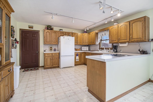 kitchen featuring brown cabinetry, white appliances, a sink, and light floors
