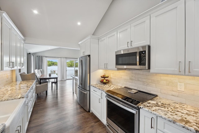 11449 Sunset Blvd, Pinckney, MI 48169 - kitchen with appliances with stainless steel finishes, vaulted ceiling, white cabinetry, backsplash, and light stone countertops