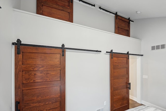 11449 Sunset Blvd, Pinckney, MI 48169 - detailed view of a barn door, baseboards, a smoke detector, and wood finished floors