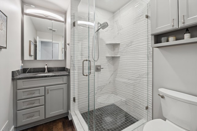 11449 Sunset Blvd, Pinckney, MI 48169 - bathroom with vanity, toilet, a stall shower, and wood finished floors