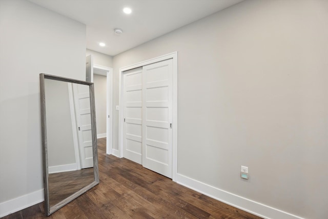 11449 Sunset Blvd, Pinckney, MI 48169 - unfurnished bedroom featuring baseboards, dark wood-style flooring, recessed lighting, and a closet