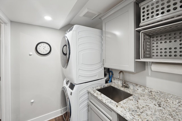 11449 Sunset Blvd, Pinckney, MI 48169 - laundry area featuring stacked washer / drying machine, a sink, wood finished floors, recessed lighting, and baseboards