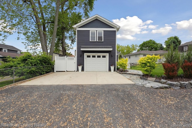 11449 Sunset Blvd, Pinckney, MI 48169 - view of front of house with asphalt driveway, an attached garage, and a gate