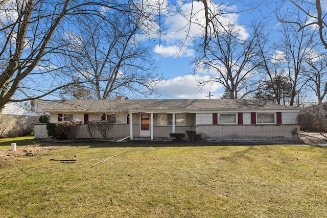single story home featuring a chimney, a front lawn, and brick siding