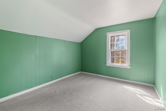 additional living space with baseboards, vaulted ceiling, and carpet floors