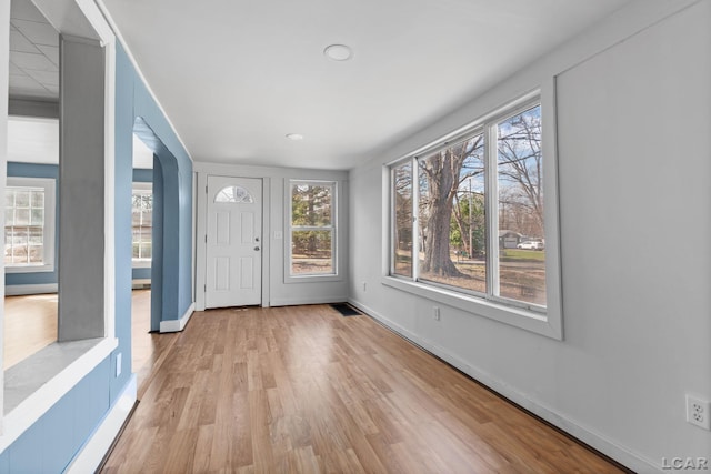 interior space featuring light wood-style floors, baseboards, and visible vents
