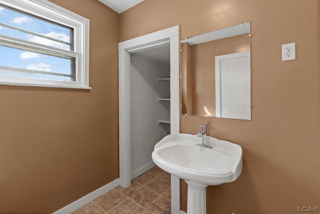bathroom with tile patterned floors, baseboards, and a sink