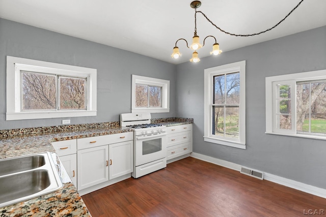 kitchen with a sink, visible vents, white gas range oven, and a healthy amount of sunlight