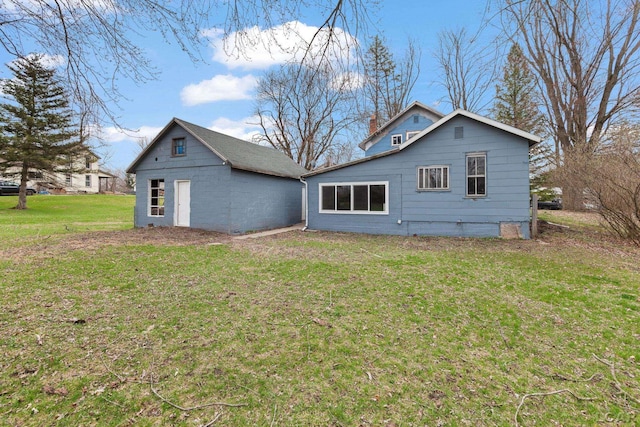 rear view of property featuring a yard and a chimney