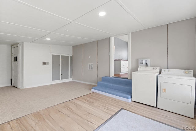 laundry area featuring visible vents, washer and clothes dryer, wood finished floors, and laundry area