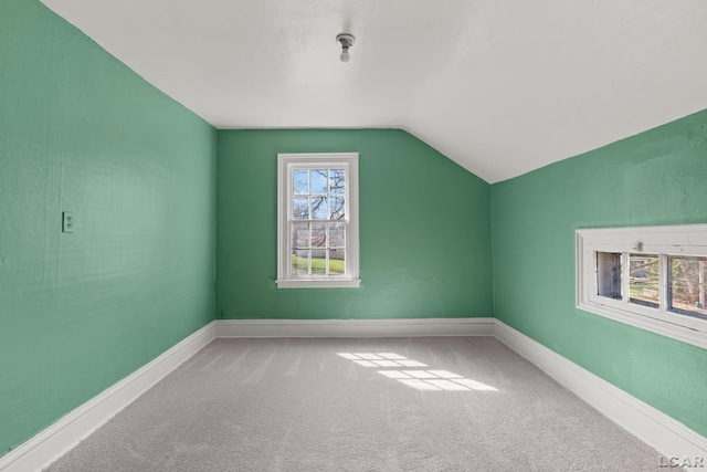 additional living space with carpet flooring, baseboards, and vaulted ceiling