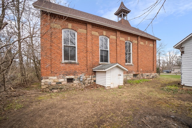 208 N Portage Rd, Jackson, MI 49201 - rear view of house featuring brick siding and a shingled roof