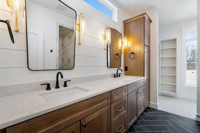 bathroom featuring healthy amount of natural light, double vanity, and tile patterned flooring