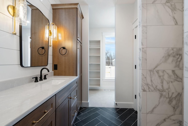 bathroom featuring vanity, tile patterned flooring, and baseboards