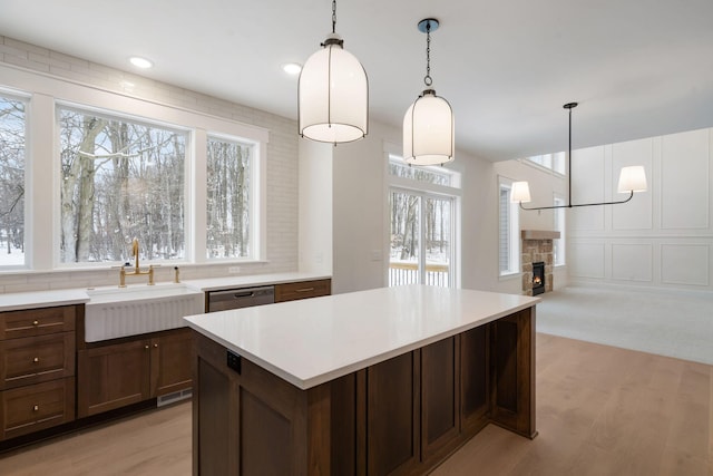kitchen with a sink, light wood-style floors, light countertops, and recessed lighting