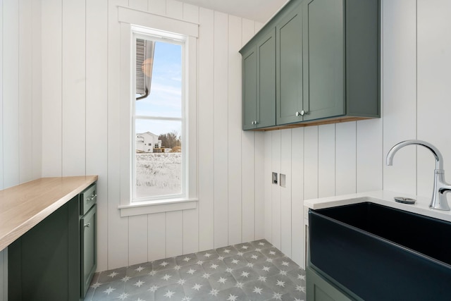 laundry area featuring tile patterned floors and cabinet space