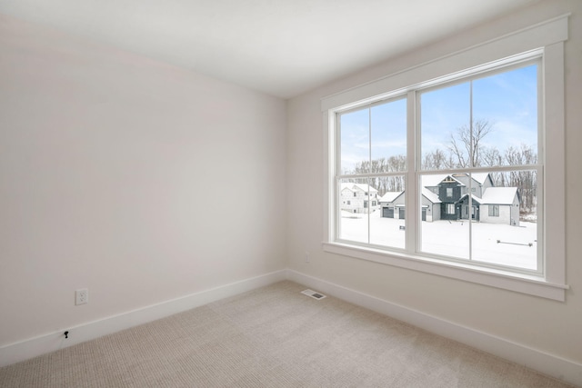 carpeted spare room with baseboards and plenty of natural light