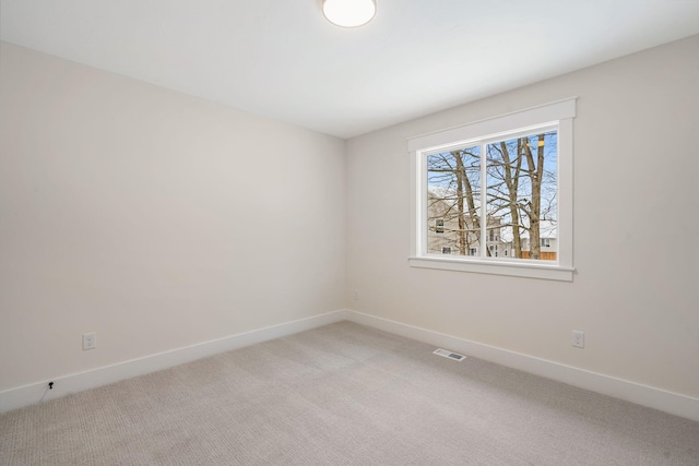 spare room with light carpet and baseboards