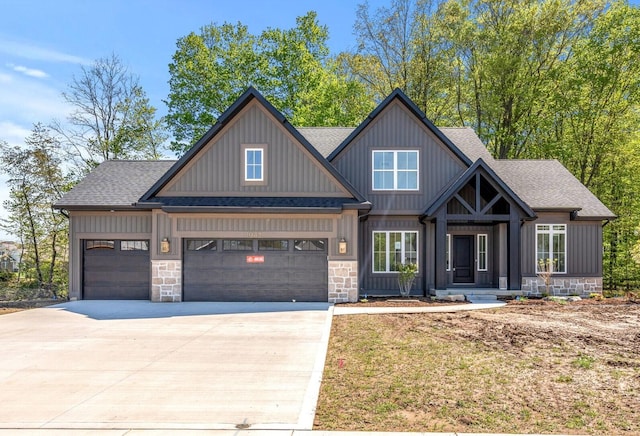 craftsman-style home with roof with shingles, driveway, a garage, and stone siding