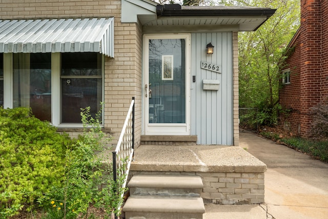 doorway to property featuring brick siding