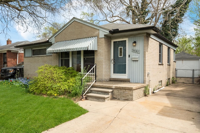 view of front of home featuring board and batten siding, a front yard, a garage, brick siding, and concrete driveway