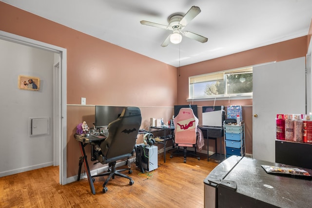 office area featuring baseboards, a ceiling fan, and wood finished floors