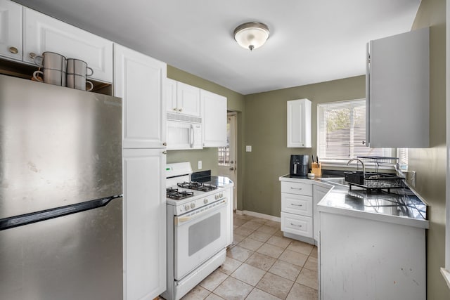kitchen featuring a sink, light tile patterned flooring, white cabinets, and white appliances