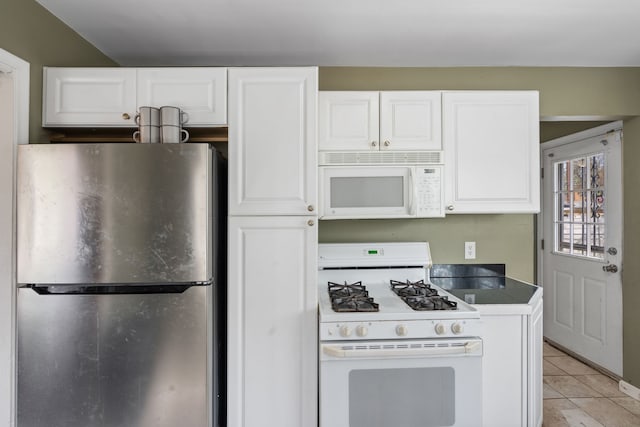 kitchen featuring light tile patterned flooring, white cabinets, and white appliances