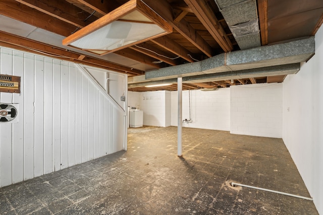 below grade area with concrete block wall and washer / dryer