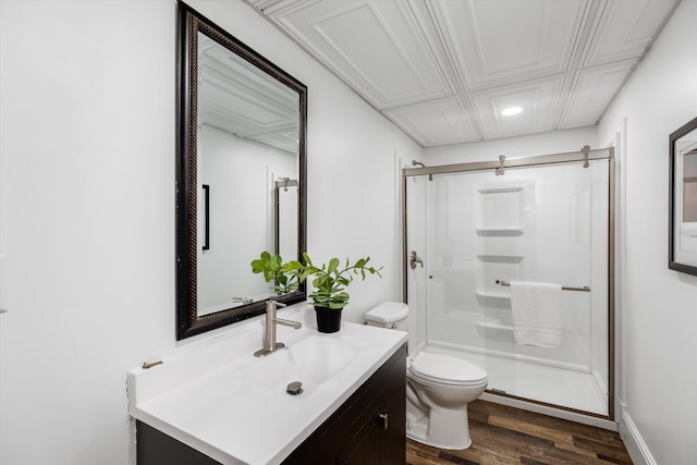 full bathroom featuring wood finished floors, a stall shower, toilet, vanity, and recessed lighting