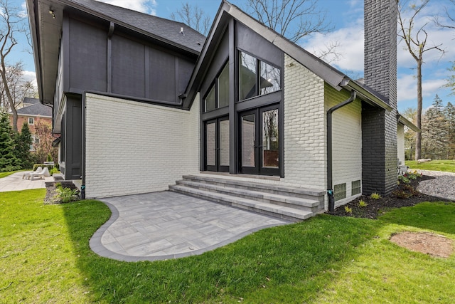 245 Chestnut Cir, Bloomfield Hills, MI 48304 - rear view of property featuring a chimney, brick siding, entry steps, and a yard