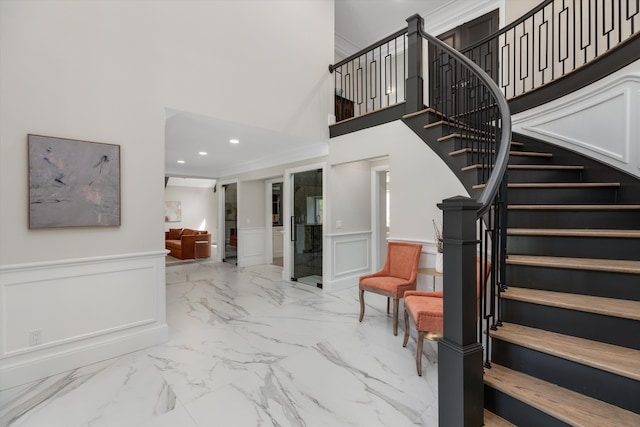 245 Chestnut Cir, Bloomfield Hills, MI 48304 - staircase featuring a decorative wall, marble finish flooring, a wainscoted wall, a towering ceiling, and recessed lighting