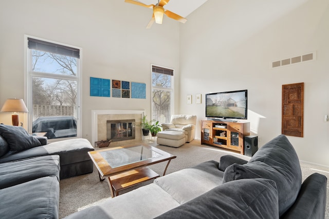 1826 Poppleton Dr, West Bloomfield, MI 48324 - carpeted living area featuring visible vents, ceiling fan, a tile fireplace, and a towering ceiling