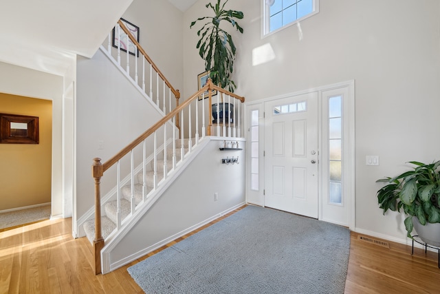 1826 Poppleton Dr, West Bloomfield, MI 48324 - foyer featuring visible vents, baseboards, a high ceiling, wood finished floors, and stairs