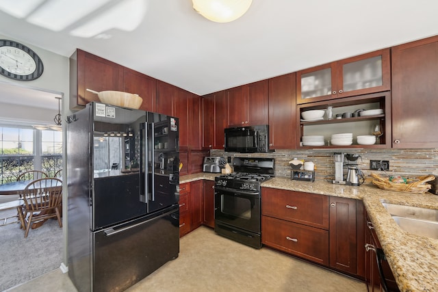 1826 Poppleton Dr, West Bloomfield, MI 48324 - kitchen featuring tasteful backsplash, glass insert cabinets, light stone countertops, black appliances, and reddish brown cabinets