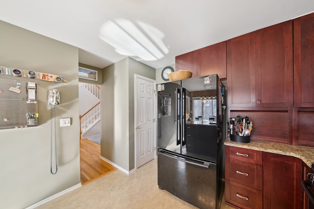 1826 Poppleton Dr, West Bloomfield, MI 48324 - kitchen featuring light stone countertops, baseboards, freestanding refrigerator, and dark brown cabinets