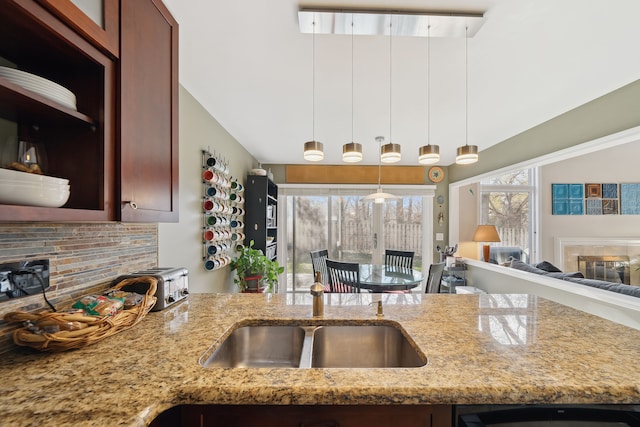 1826 Poppleton Dr, West Bloomfield, MI 48324 - kitchen featuring light stone countertops, tasteful backsplash, a sink, hanging light fixtures, and open floor plan