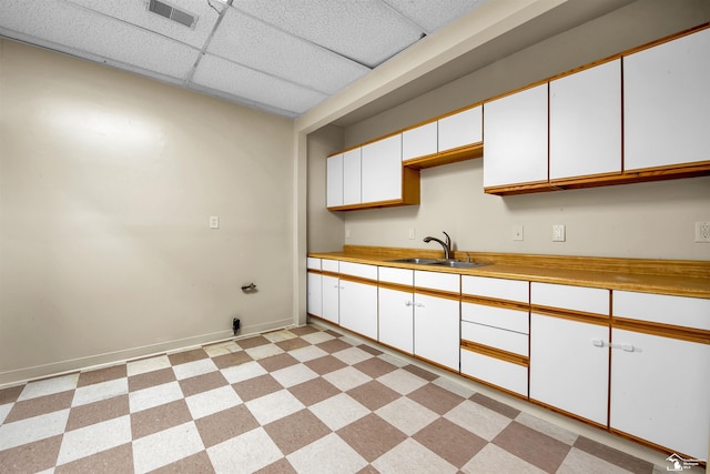 12800 Matthews St, Carleton, MI 48117 - kitchen with a paneled ceiling, a sink, white cabinets, baseboards, and light countertops