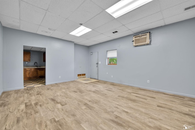 12800 Matthews St, Carleton, MI 48117 - unfurnished room featuring a paneled ceiling, light wood-type flooring, a wall mounted air conditioner, and baseboards