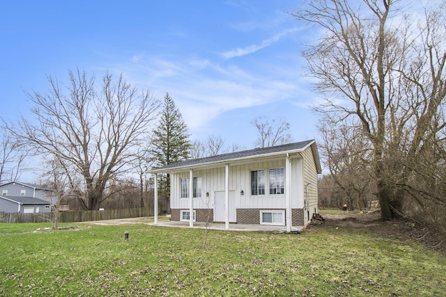 bi-level home featuring a patio area, fence, and a front lawn