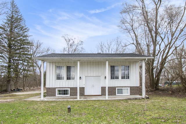 raised ranch with a front yard and board and batten siding