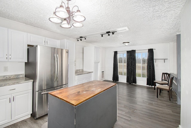 kitchen with freestanding refrigerator, a chandelier, white cabinetry, light wood finished floors, and butcher block countertops